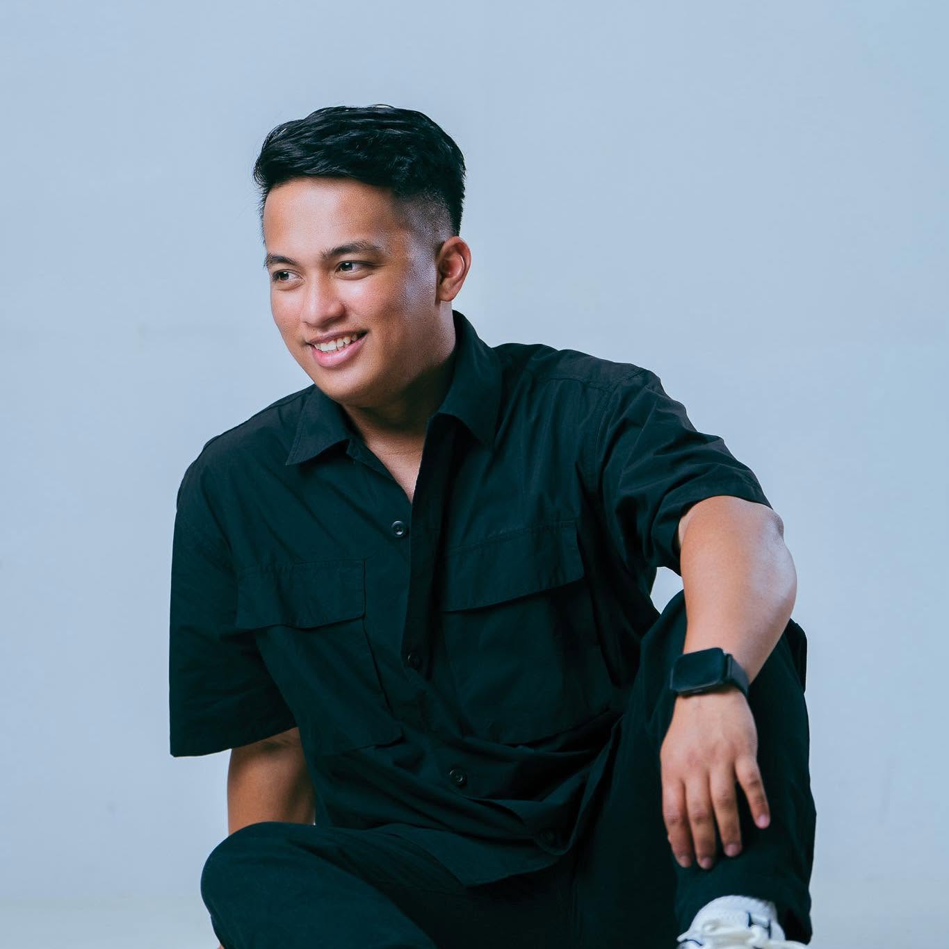 Ken Garcia seated and smiling, wearing a dark green shirt